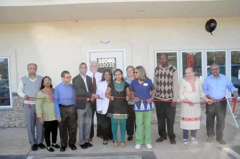 Shown at the ribbon cutting are (l-r) Priyavadan Sheth; Sohini Sheth; Bobbi Riddick; Nancy Westfall, pharmacy assistant; Aimee Nailor; Ankita Sheth; Lakshami Reddy, staff pharmacist; Bruce Benton, staff pharmacist; Tejas Sheth, pharmacist and owner; Niraj Kadakia; Shaku Kadakia; and Ravindra Kadakia. BY STEVEN BILLUPS