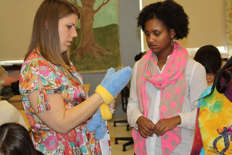 Teacher Alayna Aiken inspects a pair of Cape-colored mittens made by Michiah Rushin, 16. BY MELISSA STEELE