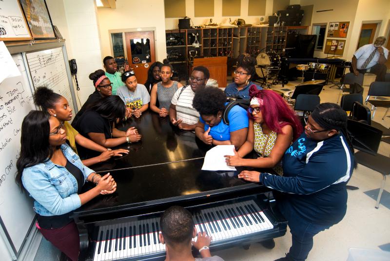 As they gather around a piano in the music room at Cape High, the group begins to sing together in one voice in a powerful soulful tune. Caleb Jones plays piano for the singers (l-r) Shayla Brittingham, Niya Mosley, Mari Horsey, Angel Cox, Shayne Brittingham, Keila Saez, Denay Cox, Cainijia Mosley, Byron Sivels, Brittany Copper, Heaven Cox, Jenay Cox and Jaysmine Lewis. William Waters watches over the group in back. BY DENY HOWETH