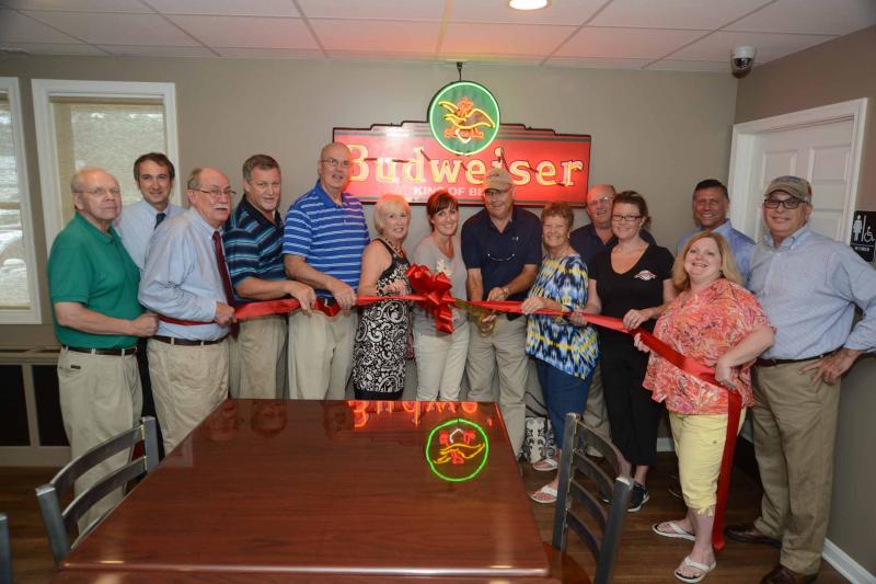 Shown at the ribbon cutting, under a sign that hung in the original Stockley Tavern, are (l-r) Bob Stickels; Charlie Koskey; Ray Hopkins; Tim Dukes, R.-Laurel; Mike Vincent, County Council; Ruth Briggs King, R-Georgetown; Stockley Tavern co-owners Tracy and Ken Adams; Chris LeCates, Georgetown Town Council; Georgetown Mayor Bill West; Samantha Ruark, manager; Angela Emerson, Georgetown Chamber president; Steve Smyk, R-Milton; and Danny Short, R-Seaford. STEVEN BILLUPS PHOTO ribbon cutting