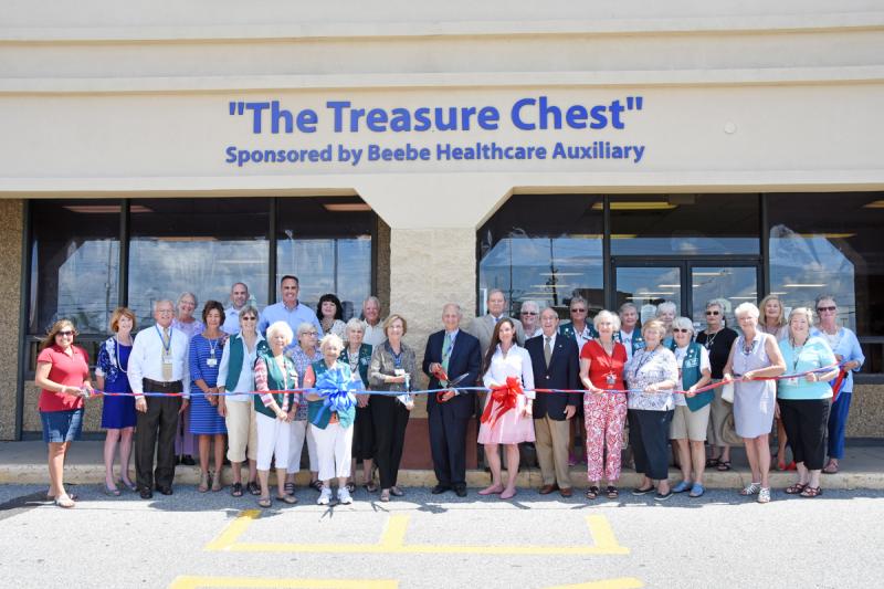 Beebe Healthcare President and CEO Jeffrey Fried cuts the ribbon to celebrate the grand reopening of the Beebe Treasure Chest Thrift Shop. He is joined by (l-r) Patty Burkentine, Rehoboth Beach-Dewey Beach Chamber of Commerce; Betsy Reamer, executive director of Lewes Chamber of Commerce; C. Wendell Alfred, past president of Beebe Auxiliary; Rosey Vanderhoogt, auxiliary recording secretary; Bonnie Cunningham and Ken Carson, both of Beebe Wound Healing & Hyperbaric Medicine; Kathi Gelwicks, volunteer; Peggy Weaver, volunteer; Sen. Ernie Lopez, R-Lewes; Andreé Catalfamo, volunteer; Mary DeVries, volunteer; Lynn Wilkins, Beebe Healthcare 100th Anniversary History Committee co-chair and executive assistant, Office of the President; Martha Tutak, volunteer; Dennis Reardon, Lewes city councilman; Nancy Tartaglione, Beebe Auxiliary president; Fried; Tommy Cooper, chair of Beebe Medical Foundation; Amanda Deschenes, thrift shop manager; Myrna Kelley, volunteer; David A. Herbert, vice chairman, Beebe Board of...