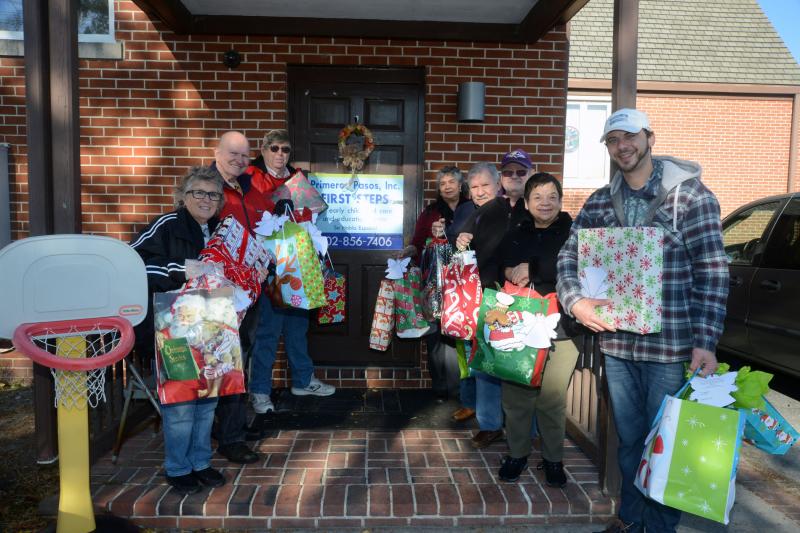 Volunteers and Feed the Children directors gathered at the entrance of Primeros Pasos at St. Paul’s Episcopal Church in Georgetown with the many gifts for the children. Shown are (l-r) Christine Miller‐Marcin, postulant for holy orders in the Diaconate of the Episcopal Church and founder of Feed the Children at St. Peter’s; Will Wical, Ed Chamberlain, co-director; Maria Joseph, site director; Harvey Holthaus; Michael Seifert; Tina Wical, communications director; and Zach Krytzer. primeros Pasos
