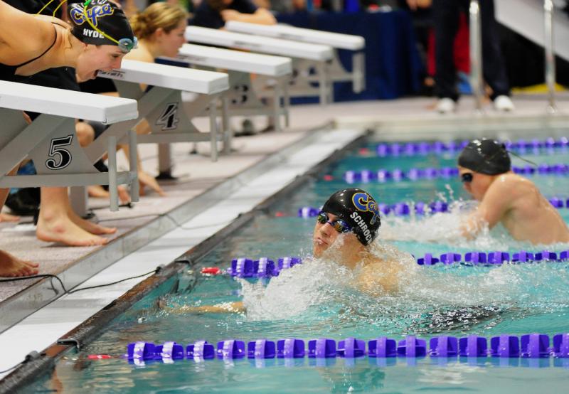 Cape’s 100 breaststroke winner Michael Schrock makes a turn while teammate Sarah Hyde cheers him on to his 1:09.68 victory. DAN COOK PHOTO