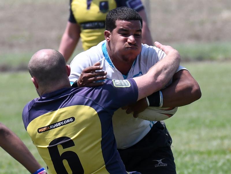Delmarva Rugby Club’s Keith Jones, a former Sussex Central athlete, plows through a Media Rugby player during the Son of a Beach Tournament. DAN COOK PHOTO
