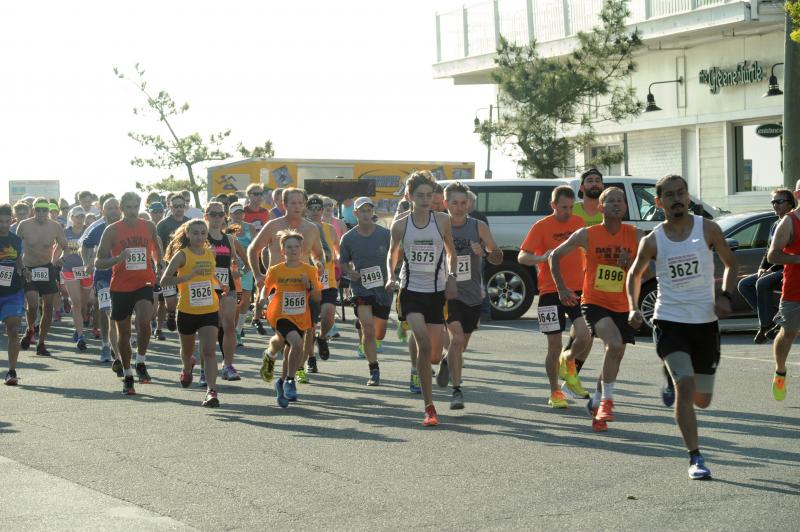 Flaring from the bright sun, runners race down Wilmington Avenue for a 5K race. DAVE FREDERICK PHOTO