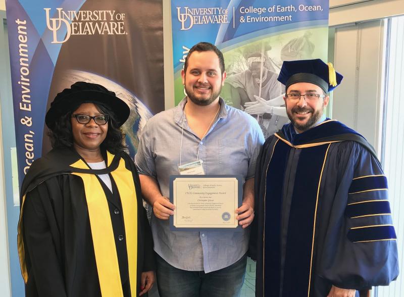 Christopher Grasso received the College of Earth, Ocean and Environment Community Engagement Award, presented by Marine Advisory Service Specialist Chris Petrone. Grasso, center, is shown with College Dean Estella Atekwana, left, and Deputy Dean Fabrice Veron. He was honored for his off-campus work with local school science fairs and Sussex County organizations including Habitat for Humanity. DENNIS FORNEY PHOTO