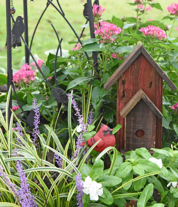 Mary and Walt Goering’s garden featured this birdhouse and faux cardinal.