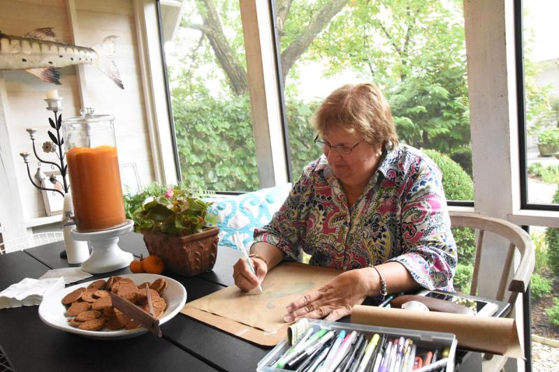 Milton Arts Guild member Lynda Rae Gannon works on a piece in the outdoor escape of Michael Hunter and David Owens.