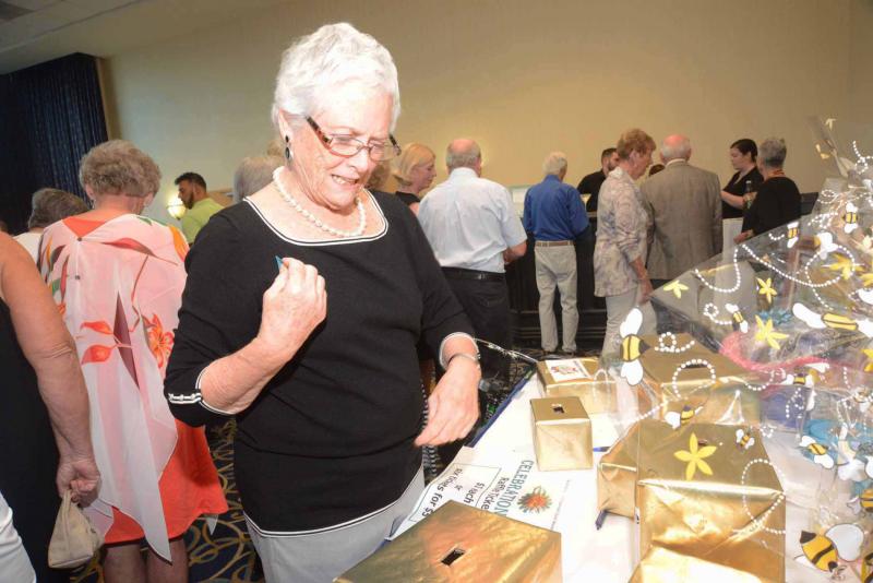 Elizabeth “Hunter” Goins tries to decide where to deposit her raffle ticket. The boxes contain gift cards from local restaurants. All Saints’ Celebration 2018