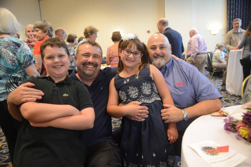 Fashion show models Alex Munson, left, and Summer Fusco relax before the show with their fathers, Marvin Muncie, back left, and Chris Fusco. All Saints’ Celebration 2018