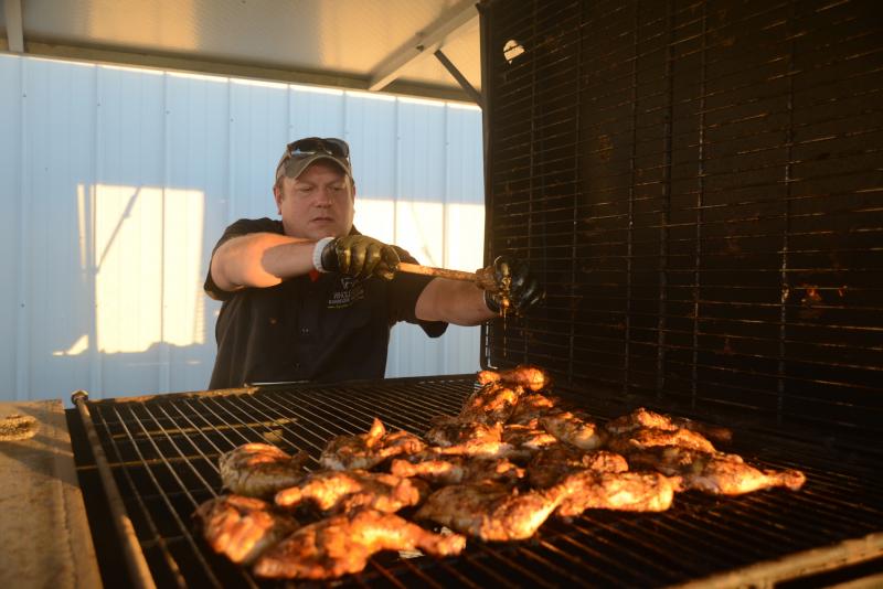 Pit Master Hank Dorsey, of Whole Roast Barbecue Service, adds a little more of his special sauce to the roast chicken. SDTR Barn Dance