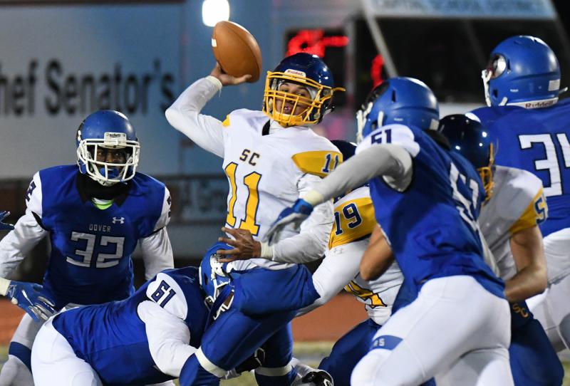 Central quarterback Isaac Barnes pulls out of the grasp of the Dover defensive line and throws downfield.