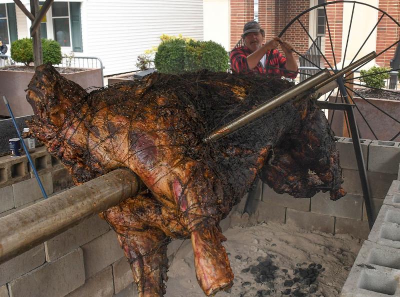 Ox roast committee member Mark Pettyjohn turns the steer on the spit. More than 1,200 pounds of beef were given away during Return Day. The Carl Freeman Foundation donated the steers for the event.