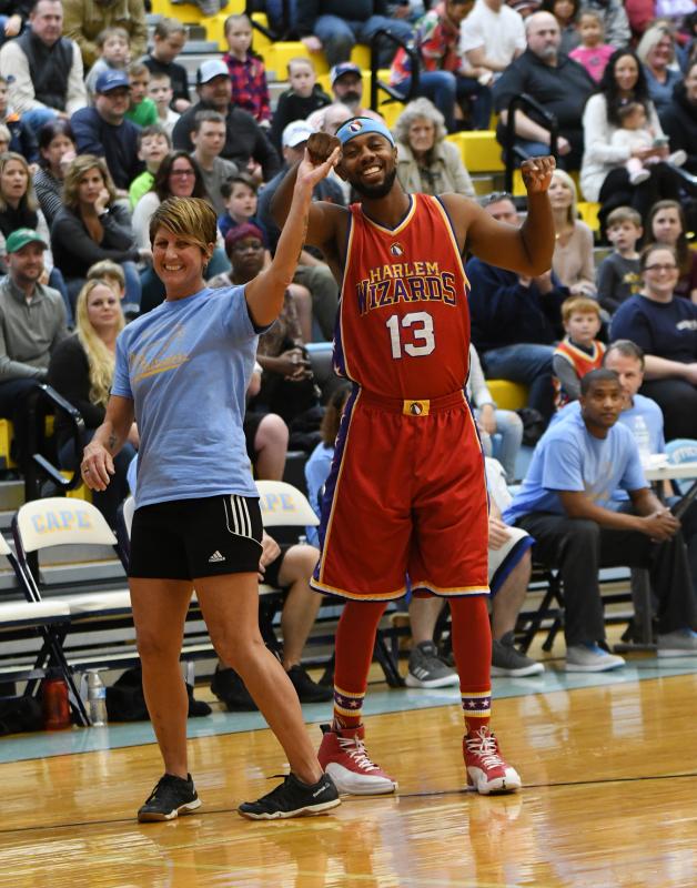 Cape Crusaders teammate and Beacon Middle School teacher Kristine Jarecki dances with Harlem Wizards player Smooth aka Robert Young.