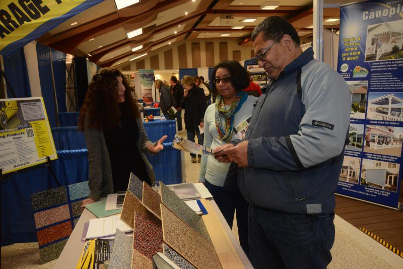 Eli and Maria Martinez from Georgetown talk with Sharon Gosack from Garage Slide Lok of the Eastern Shore. Slide Lok is a durable garage floor covering. Resort Home Fall Expo