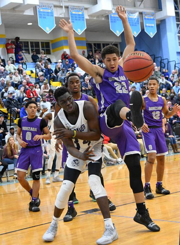 Our Savior New American’s Adama Sanogo, left, mixes it up under the basket with Gonzaga’s Myles Stute.