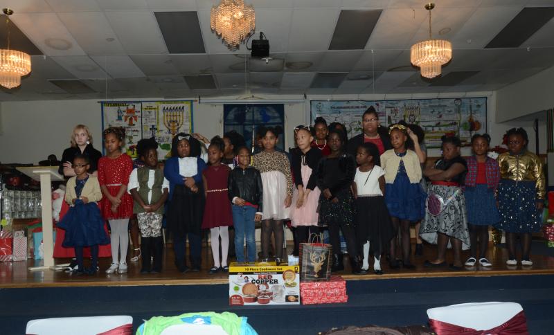 The Doll’s Tea Party members are, standing in front, (l-r) August Walker, Ariyah Johnson, Ja'Nie Wright, Ceonna Cason, Shakria Hood, Skye Pitts, Jayda Trotter, Layla Smith, Nihlaijia Bradley, Honesty Bradley, Makyra White, Kimiah Brown-Hack, Harmony White, and ZyNasia White. In back, the faces that can be clearly seen are Lacey Pearson-Gibbs, Treasure Perkins, and Timia Rossi. Doll’s Tea Party