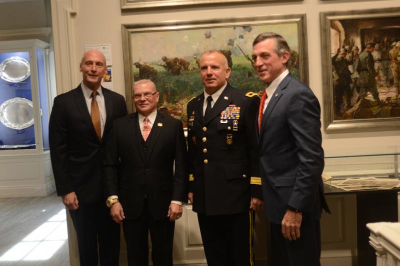 Getting the first public view of the paintings are event speakers (l-r) Delaware Secretary of State Jeffrey Bullock, Delaware State Archives Director Stephen Marz, Delaware Army National Guard Joint Staff Director Brigadier General Michael Berry, and Gov. John Carney.