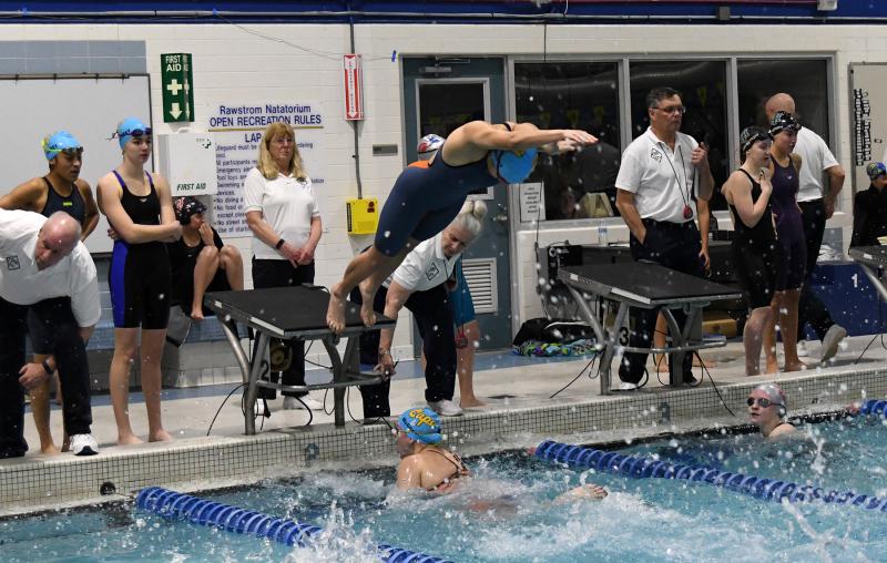 Aya Daisey takes off as Madelyn McGreevy touches up, while teammates Amaya Daisey and Erin Morrissey look on in the 200 free relay.