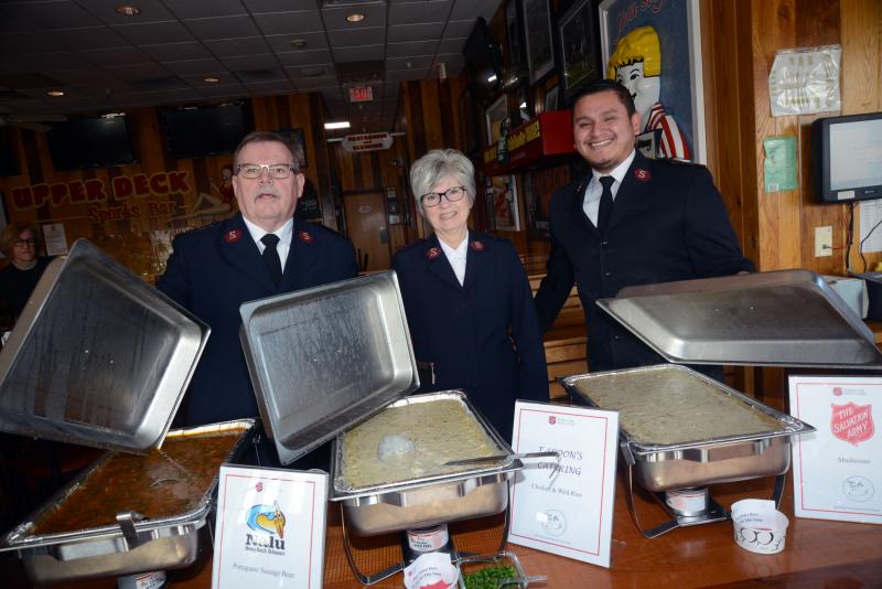 Officers from the Salvation Army open up the soup trays for a photo. Shown are (l-r) Captaincies Tim Sheehan, Captaincies Lisa Sheehan and Lt. Miguel Alban. The soup on the left, created by Nalu, a Portages Sausage Bean Soup, placed third by popular votes. The soup in the center, a wild rice chicken soup, placed second. The first-place soup was a Mulligatawny by an individual, Steven Sponaugle. Souper Bowl