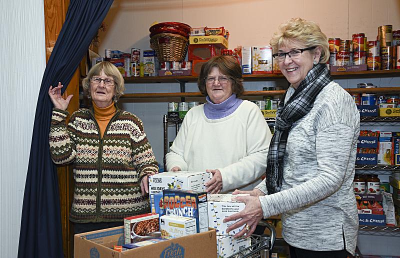 Barbara Wright, president; Christy Robinson, treasurer; and Nancy Trask, vice president of the Milton Community Food Pantry stand at the one closet they use to fill boxes for the community.