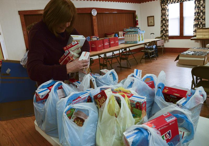 Donna Murawski is busy at the pantry packing bags after shopping, and she will be there Monday to help distribute the bags.