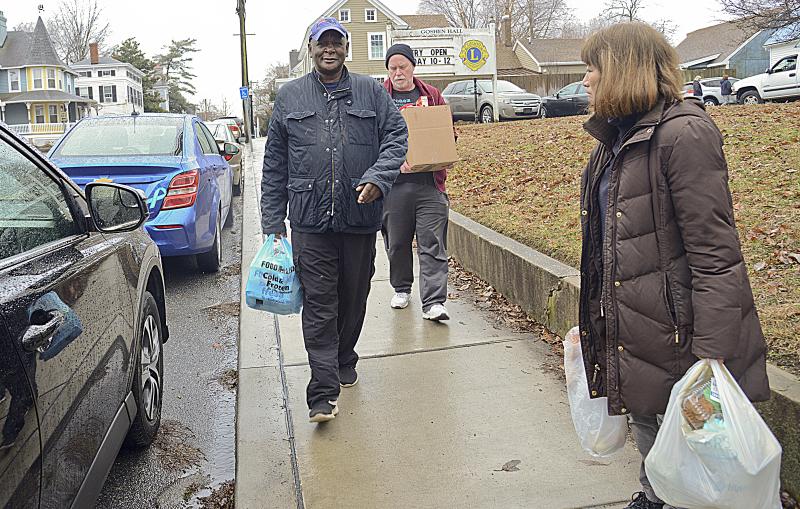 Tony Hazzard leads the way to his car, Richard Anderson and Lynne Suga-Rafanelli help carry the food for five to his car.