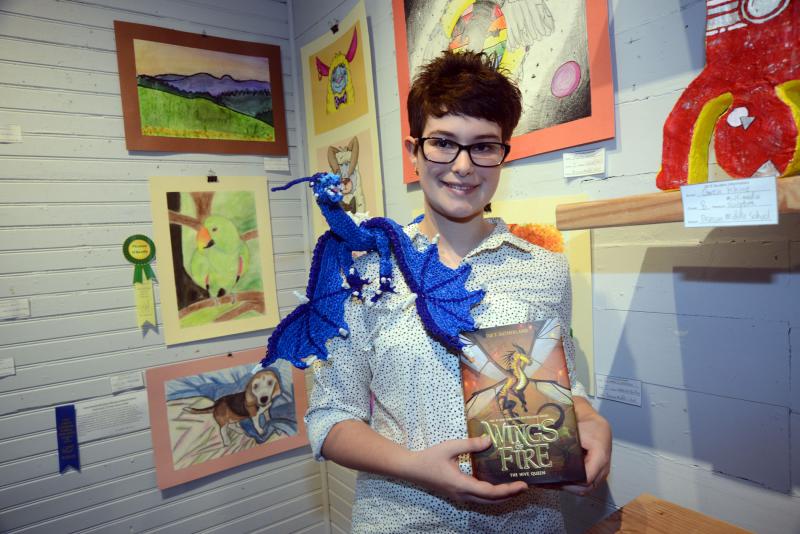 Beacon Middle School seventh-grade student Delaney Noel received the Picasso-O’Keeffe Young Artist Award for her dragon, made of rainbow loop bands. She is holding the book that inspired her project. Young at Art