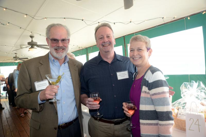 On the deck browsing raffle items are (l-r) board member Rick Schulenburg, Treasurer Steve Falcone and Helene Falcone. CRC Seeds of Change