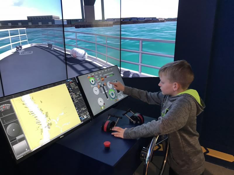 Colby Chambers takes a turn at the river pilots’ simulator. The exhibit also delves into the pilots’ history and shows in photos what the pilots do. RON MACARTHUR PHOTOS