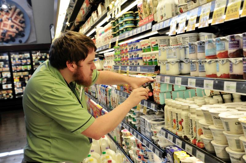 Adam Goss checks for expired products on shelves at Fresh Market in Rehoboth Beach. RON MACARTHUR PHOTO