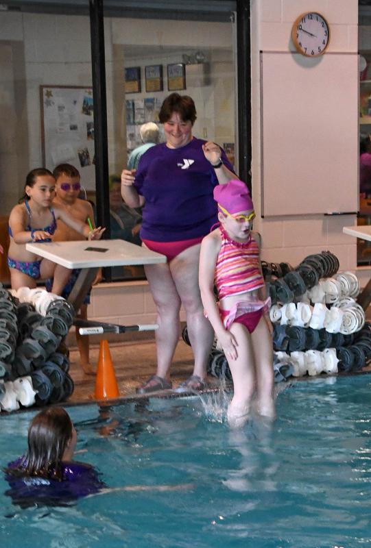 Teagan Kneifl, right, learns to jump into the pool under the watchful eyes of YMCA Aquatics Program Director Tracey Condon-Kneifl.