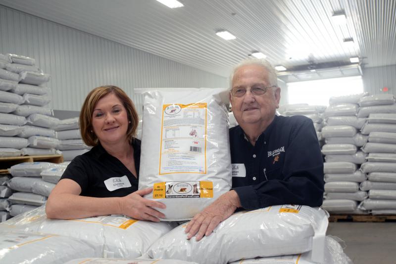 Shown in the middle of their distribution center, holding one of their products, are Christine Schrock Trivits, left, vice president of Beaverdam Pet Food, and Eli Truman Schrock II, president of Beaverdam Pet Food. Beaverdam Pet Food