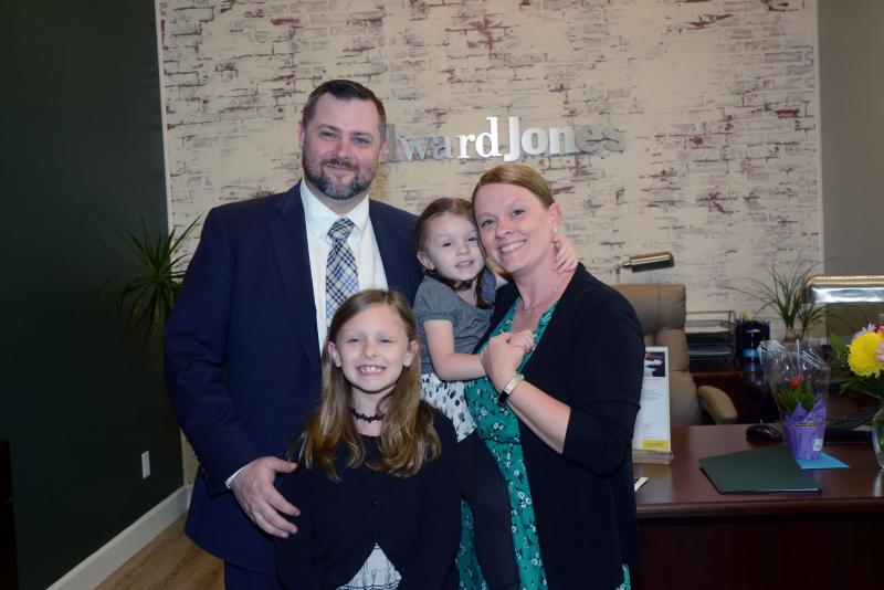 Financial advisor Glenn Sweeten smiles for a photo with his family prior to the ribbon cutting. Shown are (l-r) Sweeten, Grace and Bonnie Sweeten. In front is Bryn. Edward Jones ribbon
