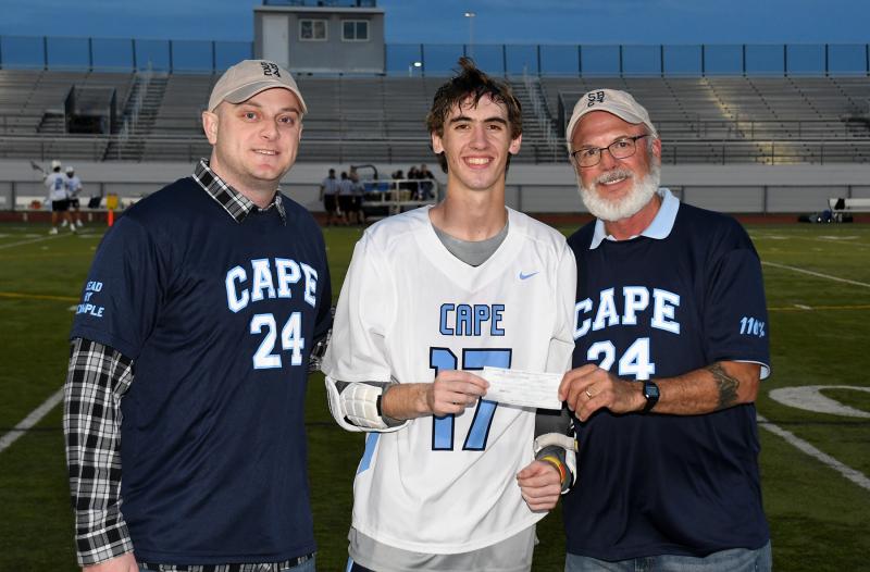 Cape lax captain Luke D’Ambrogi, center, presents Dan Cook with a check for the Scott Brozey Lead by Example Memorial Scholarship. The funds were raised from the silent auction items sold at the Caesar Rodney game May 8. Shown with them is Scott's best friend and former Cape player Franc Cook. SUBMITTED PHOTO