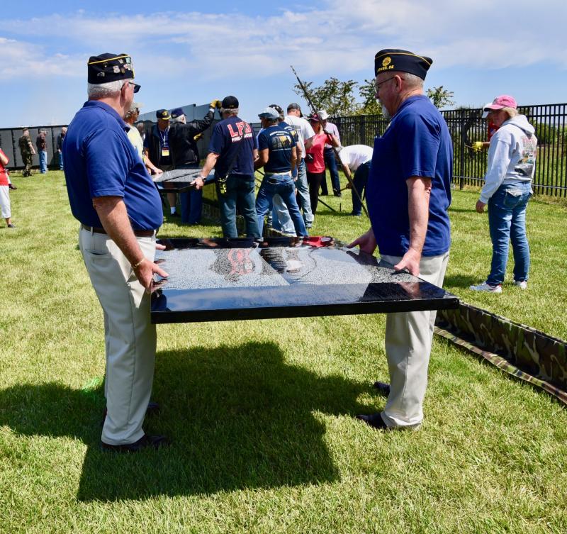 Mike Mulligan, left, Post 17 first vice commander, and Dan Catts, finance director, bring a piece of wall to be placed in a frame.