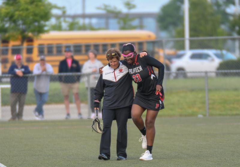Coach Lynn Richardson helps injured Lauren Tyrell off the field.