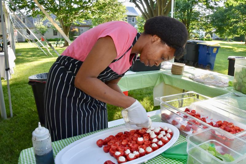 Counting House intern Shaneka Gibbs of Blades prepares strawberries for hungry feast participants. Gibbs is a student in a First State Community Action Agency program.