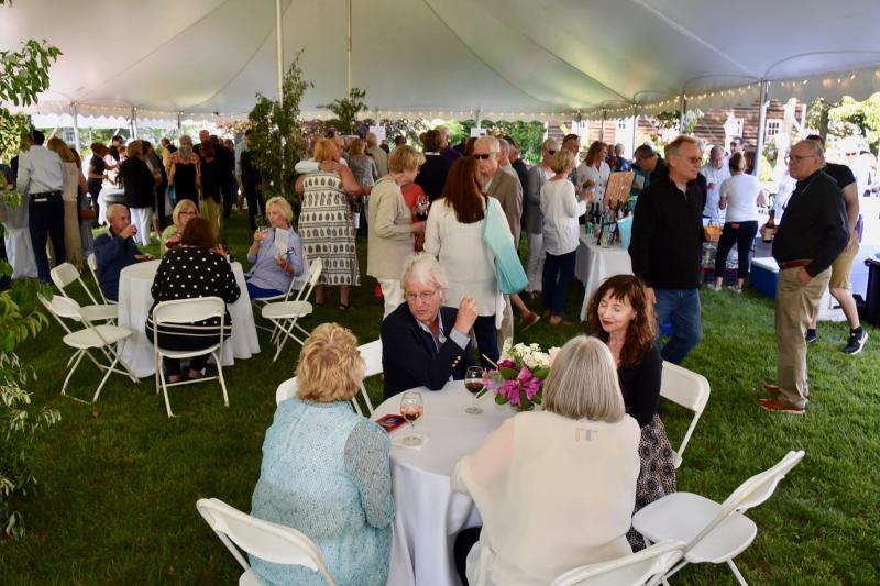 Some of the 250 market supporters gather under a tent on Shipcarpenter Green before departing to their assigned dinner location.