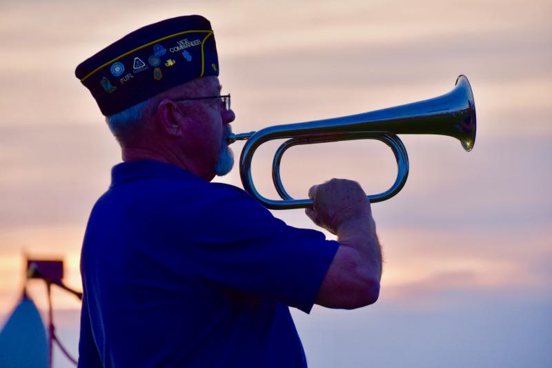 American Legion Post 17 First Vice Commander Richard Mansfield is sillouhetted by the setting sun May 19 as he plays “Taps.”