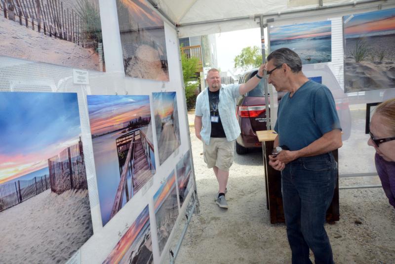 John Finelli browses C.T. Costa’s photography. DBP Arts Fest