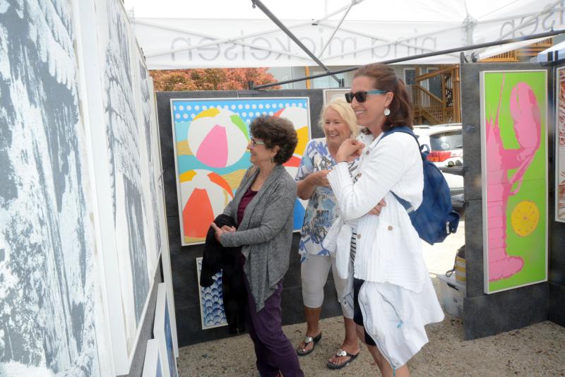 Nina Mickelsen discusses her large-scale beach paintings with customers. Shown are (l-r) Stephanie Firestone, Mickelsen, and Patty Dillon. DBP Arts Fest