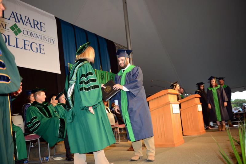 Zachary Bullis from Millsboro accepts his diploma in production agriculture from Board of Trustees Vice Chair Patti Grimes. Del Tech Commencement