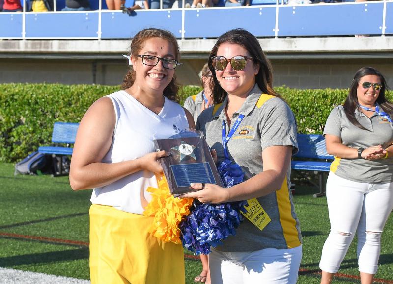 Cape’s Jasmine Mayo, left, is presented with the Outstanding Gold Cheerleader Award from coach Jen Campbell.