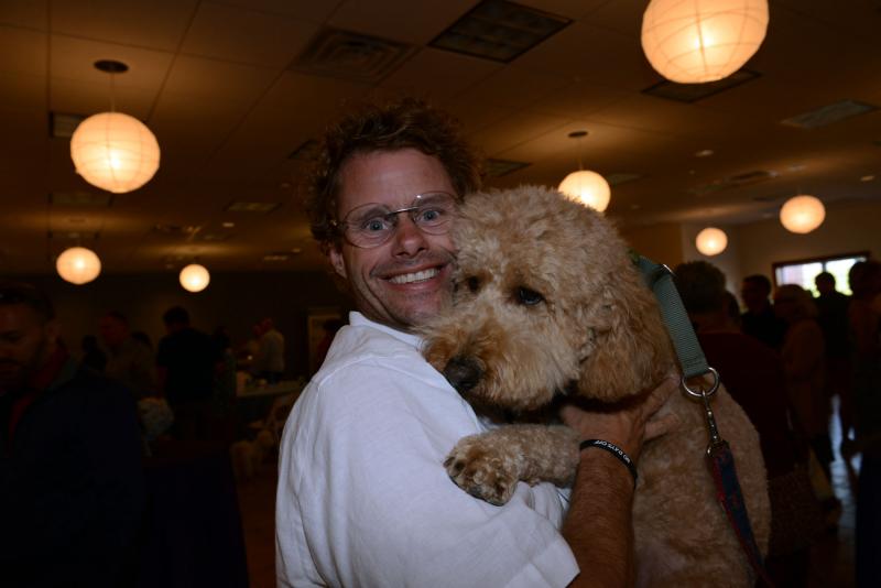 Dog lover Andy Staton gets Cooper in his arms for a photo. DHA Wags. Whiskers and Wine