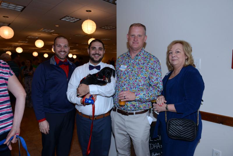Volunteers and staff gather for a photo. Shown are (l-r) volunteers Smith and Daniel Condoluci with Tucker, DHA Executive Director Patrick Carroll and DHA Director of Philanthropy Susan Lanyon. DHA Wags. Whiskers and Wine