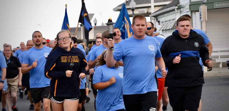 Sr. Cpl. Tim Maloney of Milford Police Department carries the flame on the first leg of the Law Enforcement Torch Run as it leaves Rehoboth Beach. The first mile was in memory of fallen officers Cpl. Christopher Shea of Delaware State Police and Patrolman Chad Spicer of Georgetown Police Department.