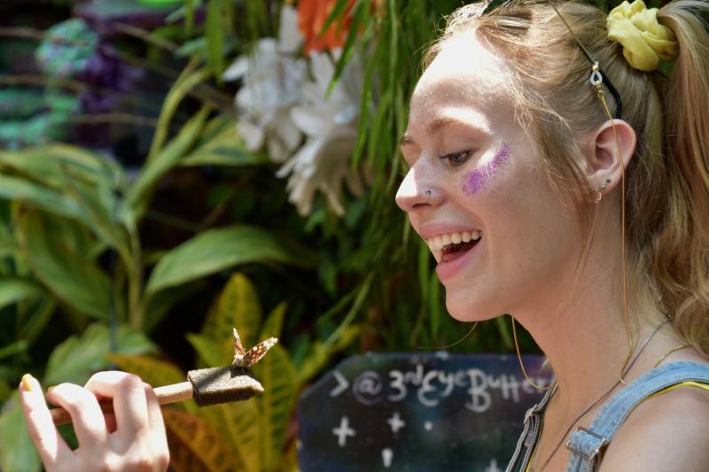 Danielle Kempf of St. Louis, Mo., is happy a butterfly landed on her in the butterfly garden experience in The Nook.