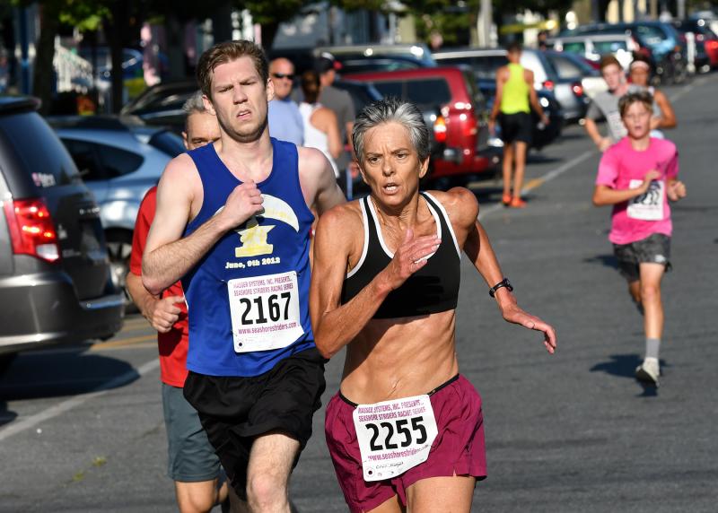 Local runner Margaret Covin, right, sprints to a time of 22:50 in front of Dylan Stanley of Fruitland, Md., who posts 22:59.
