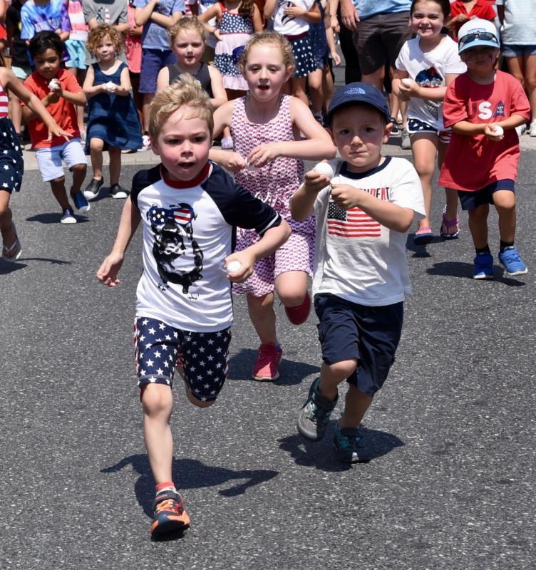 Youngsters hold on to their eggs tight as they run to the finish line in the egg race.